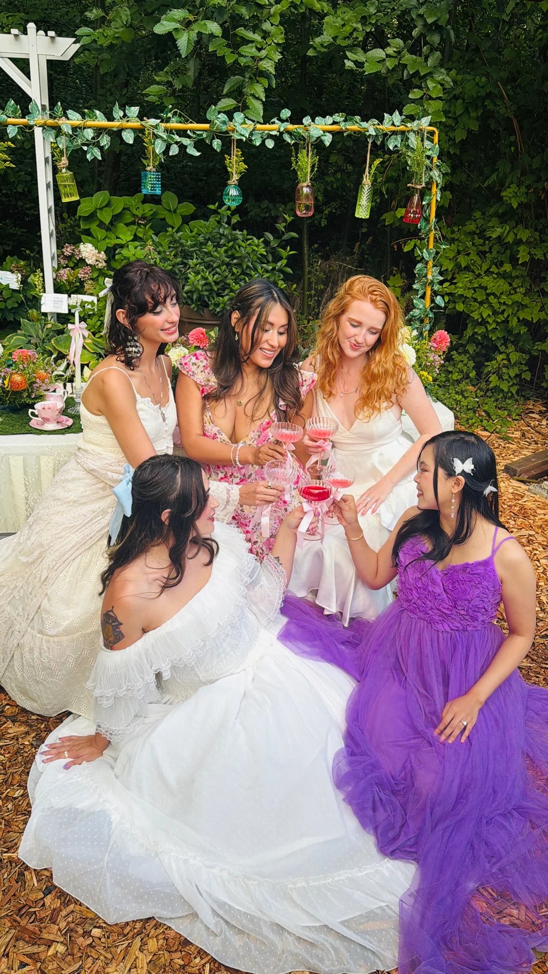 Guests raising ribbon-tied glasses for a garden toast